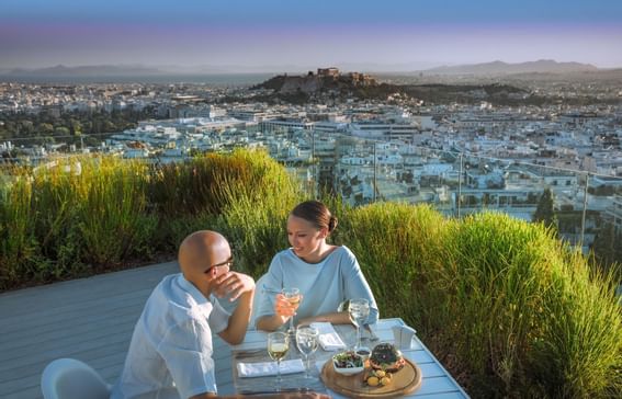 A couple dining by city view at St George Lycabettus