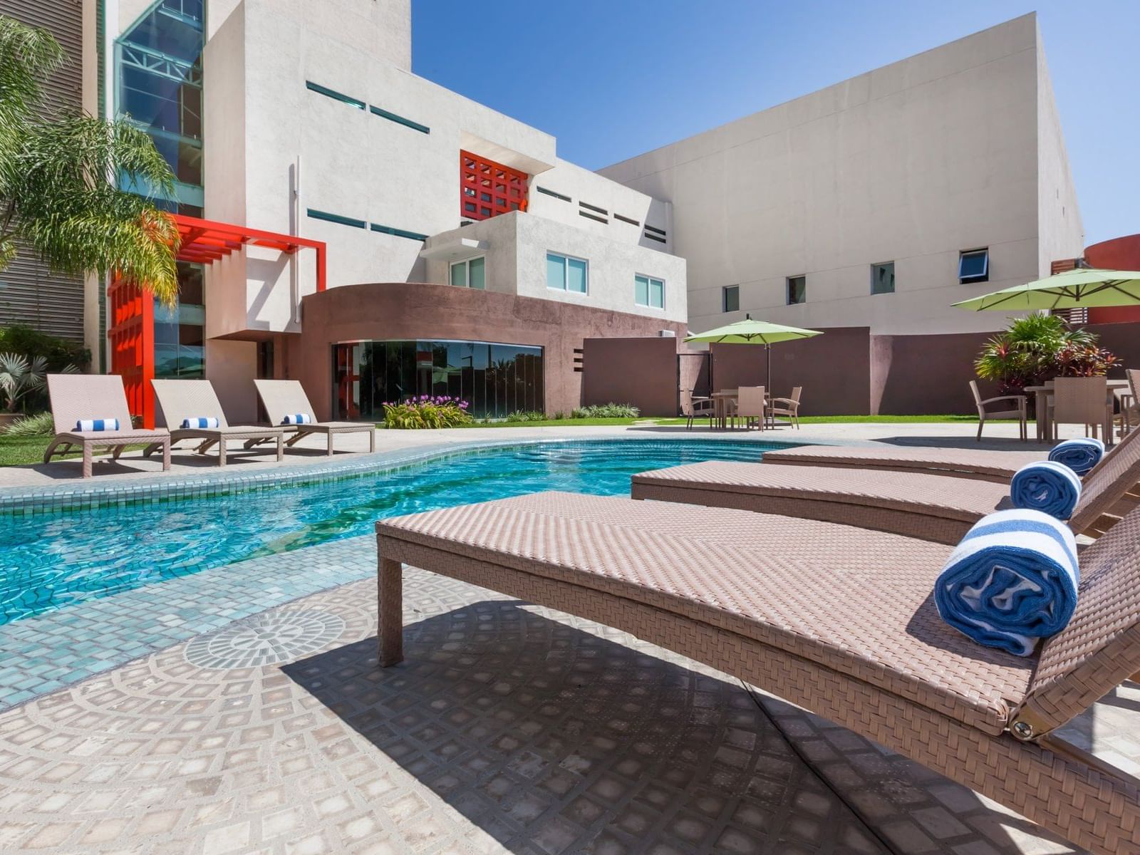 Sunbeds & towels by the outdoor pool at Gamma Hotels