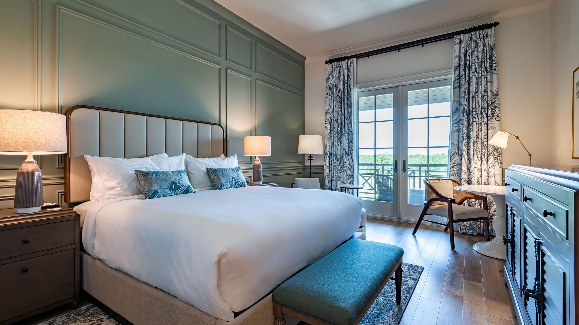 Work desk & bed by the window in Golf View King Room with Balcony at Camp Creek Inn