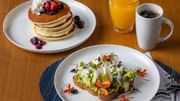 Palmea Kitchen breakfast with berry pancakes, shrimp avocado toast, orange juice, and coffee at The Diplomat Resort