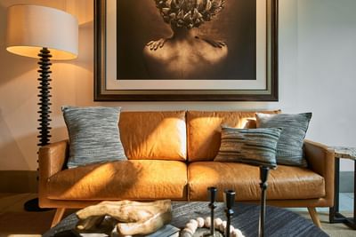Living area with a leather sofa, cushions, and a large abstract painting in Casa Cielo at Singular Signature Residences