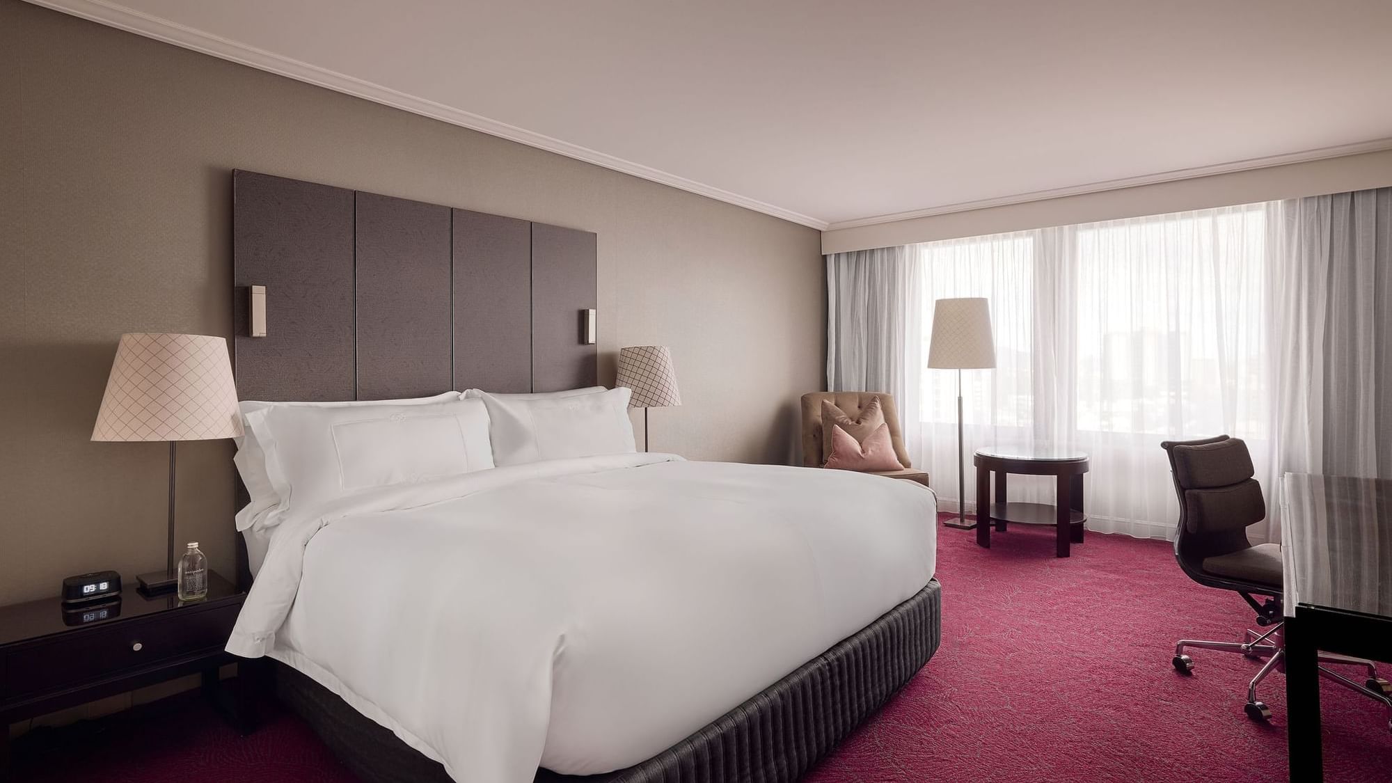 Work desk and lounge chair by the bed in Superior Room at Sofitel Brisbane Central
