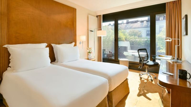 Single beds & work desk in Classic Terrace Room at Warwick Geneva