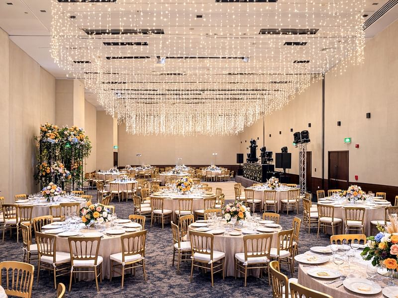 Elegant banquet hall with adorned tables under sparkling lights at Live Aqua Monterrey.