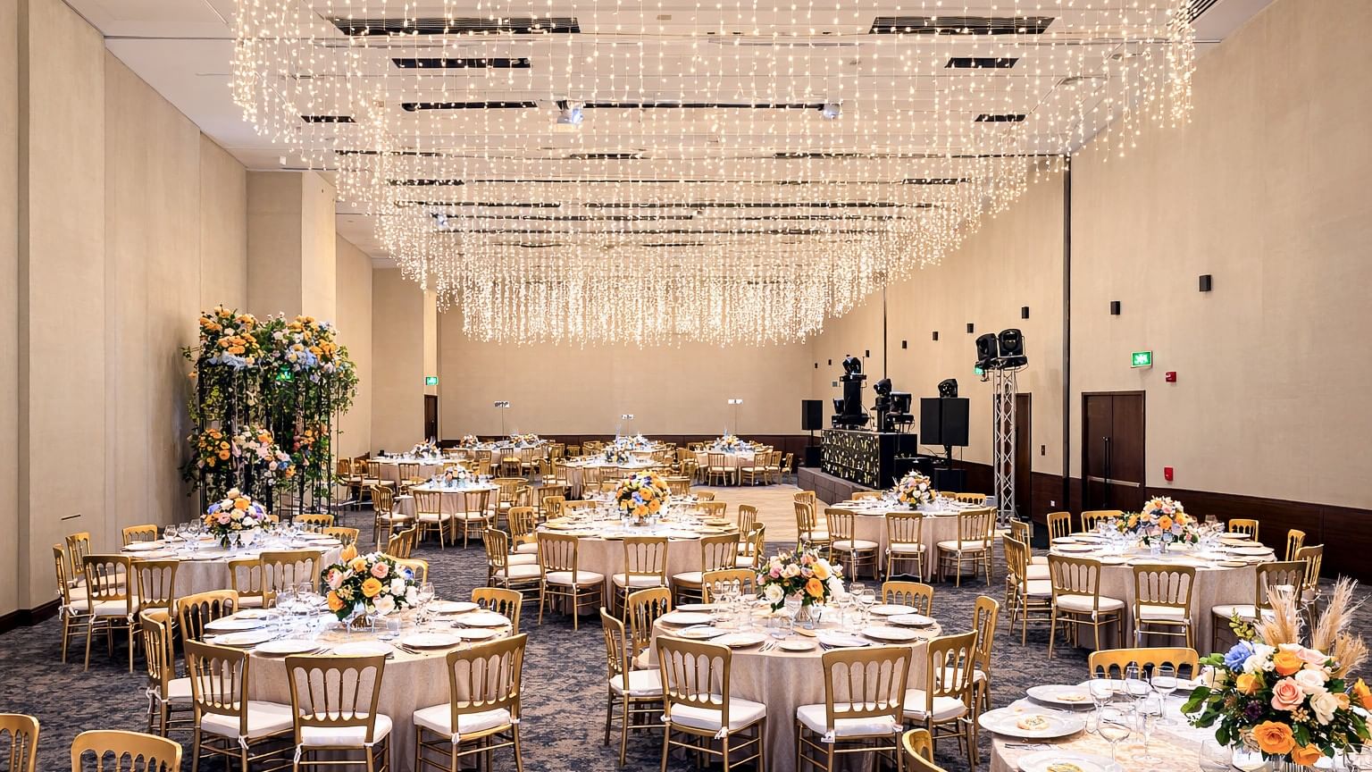 Elegant banquet hall with adorned tables under sparkling lights at Live Aqua Monterrey.