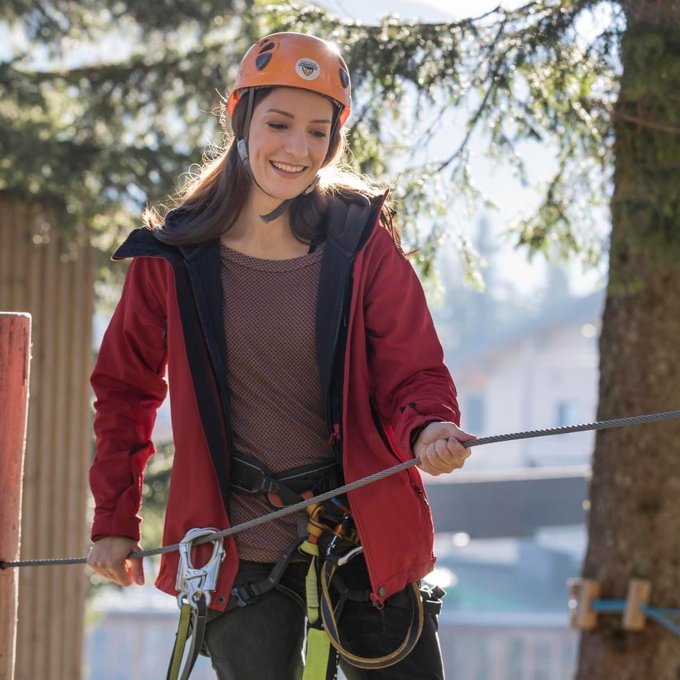 Girl engaged in a high-wire course near Falkensteiner Hotel Kronplatz