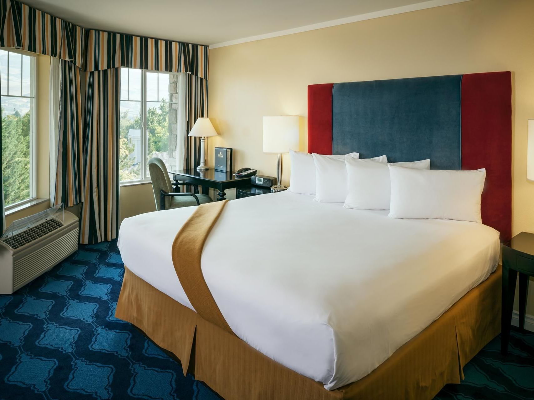 Comfy bed with Deluxe King Non-view room of Plaza Inn & Suites at Ashland Creek​