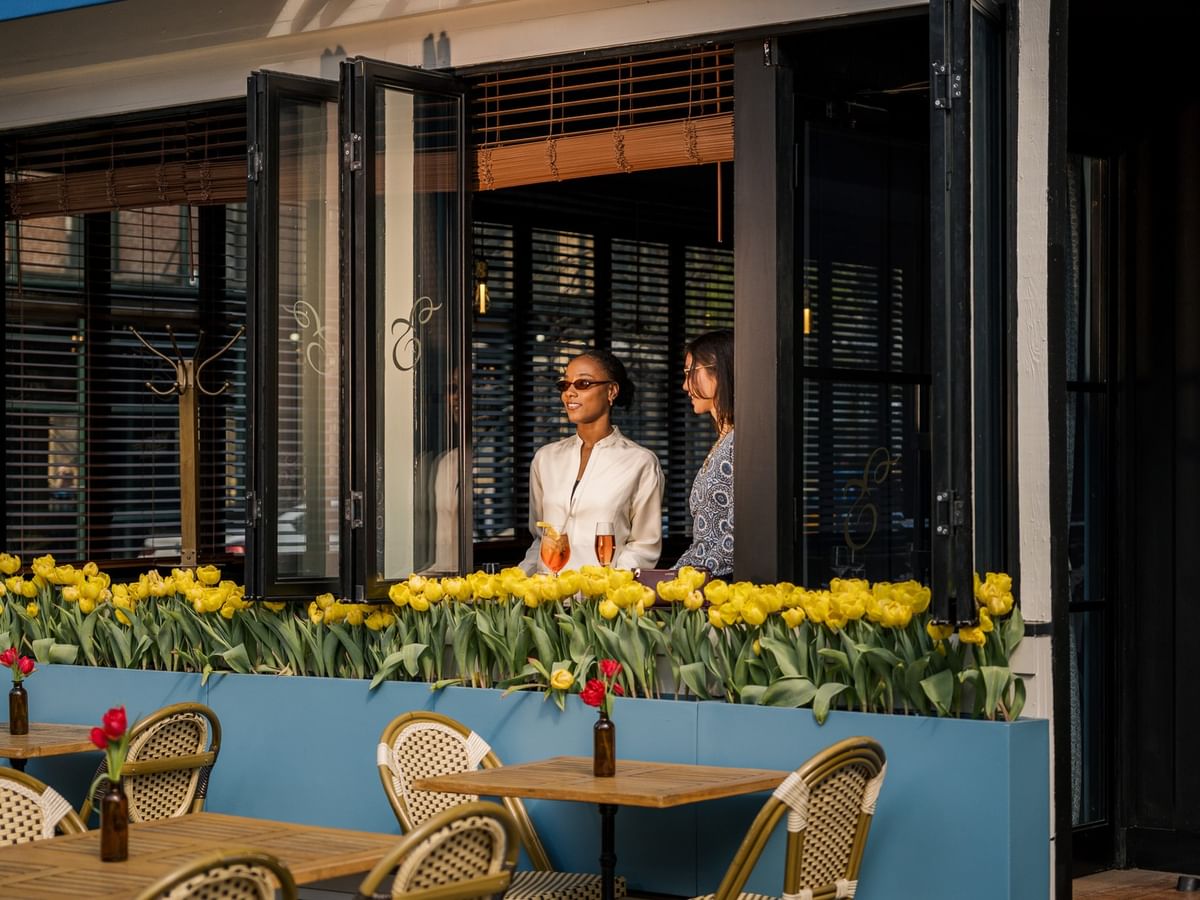 The Parlor at Estelle's outdoor patio with yellow tulips and bistro seating at Gansevoort Meatpacking NYC.