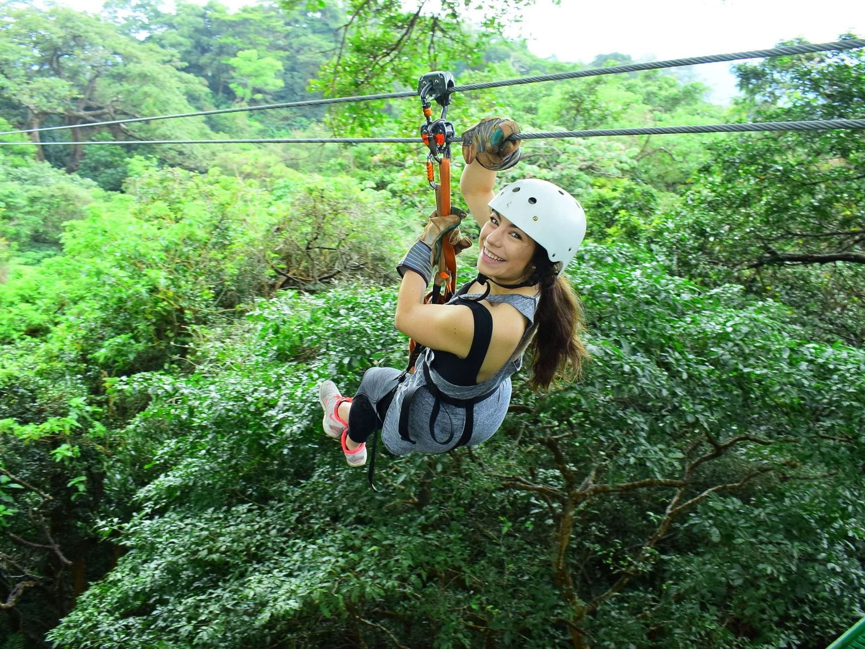 A Lady ziplining downstream near Buena Vista Del Rincon