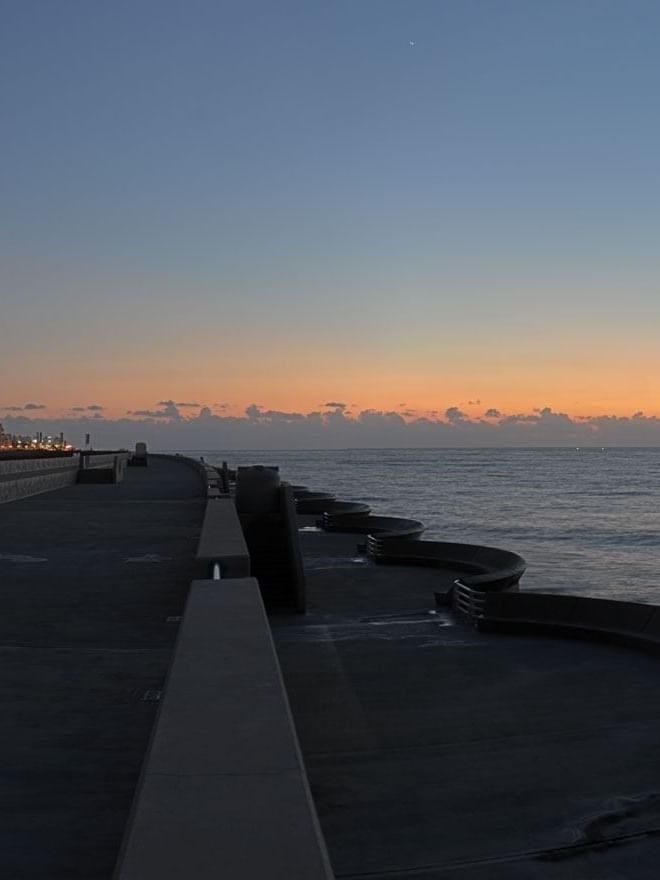 Beirut Waterfront Promenade by a walkway under an orange sunset sky near Warwick Stone 55 - Beirut