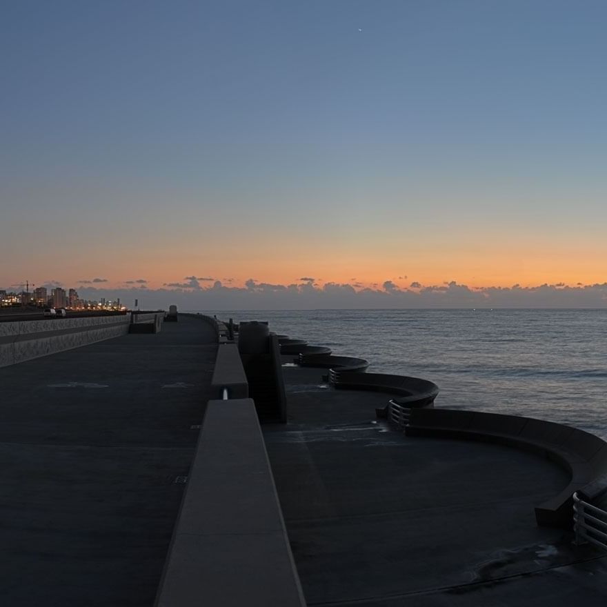 Beirut Waterfront Promenade by a walkway under an orange sunset sky near Warwick Stone 55 - Beirut