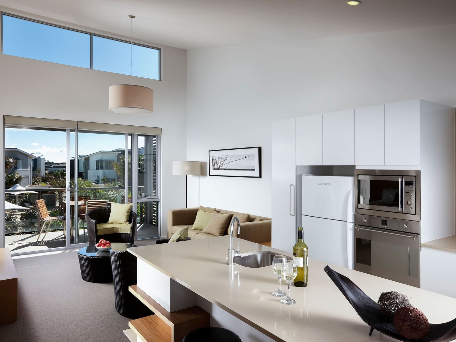 Spacious 1-bedroom villa living and kitchen area at Pullman Magenta Shores, with balcony and outdoor views.