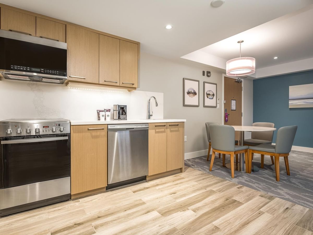 View of the full kitchen with oven, microwave, dishwasher, sink and dining area