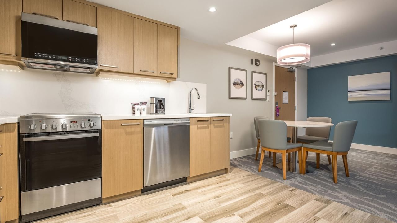 View of the full kitchen with oven, microwave, dishwasher, sink and dining area