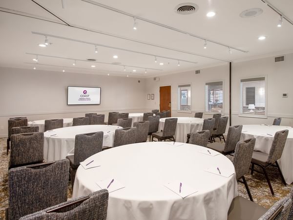 A conference room with round tables and chairs.