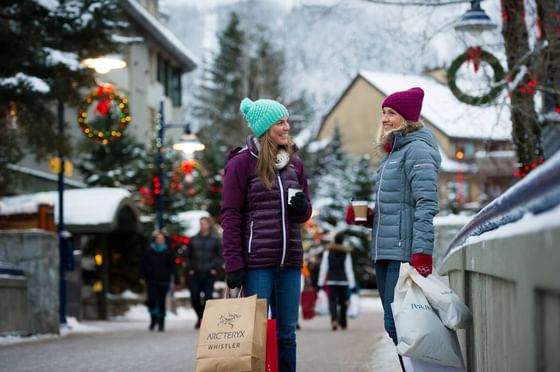 Women posing with shopping bags near Blackcomb Springs Suites