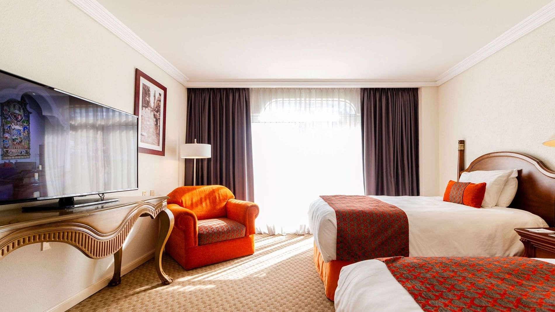 Sunny 2 Double Camino Real Club with an orange armchair and light-filtering curtains at Camino Real Puebla Angelopolis