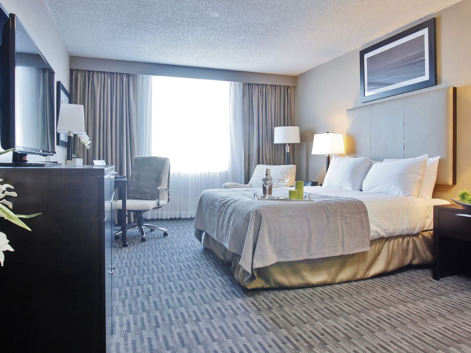 a bed facing a tv in a hotel suite