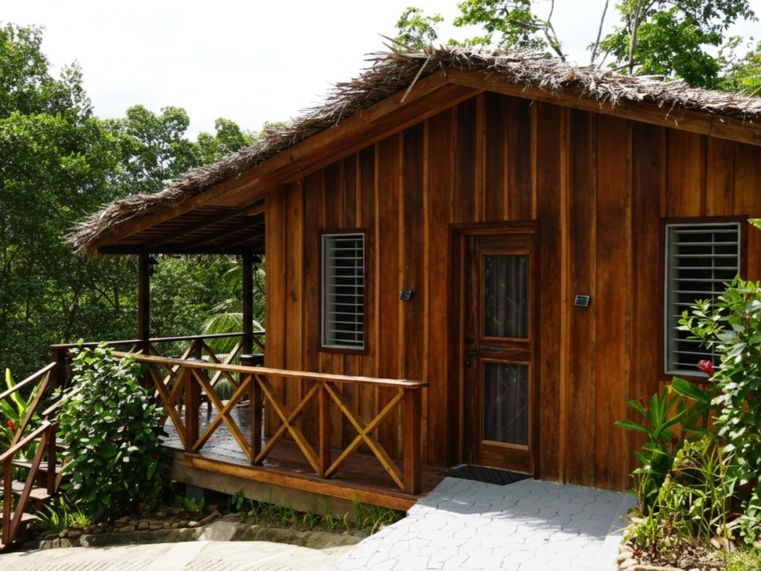 Wooden Omega cabin with thatched roof and wooden porch at Central Hotel Bocas Del Toro in Valle de Agua.