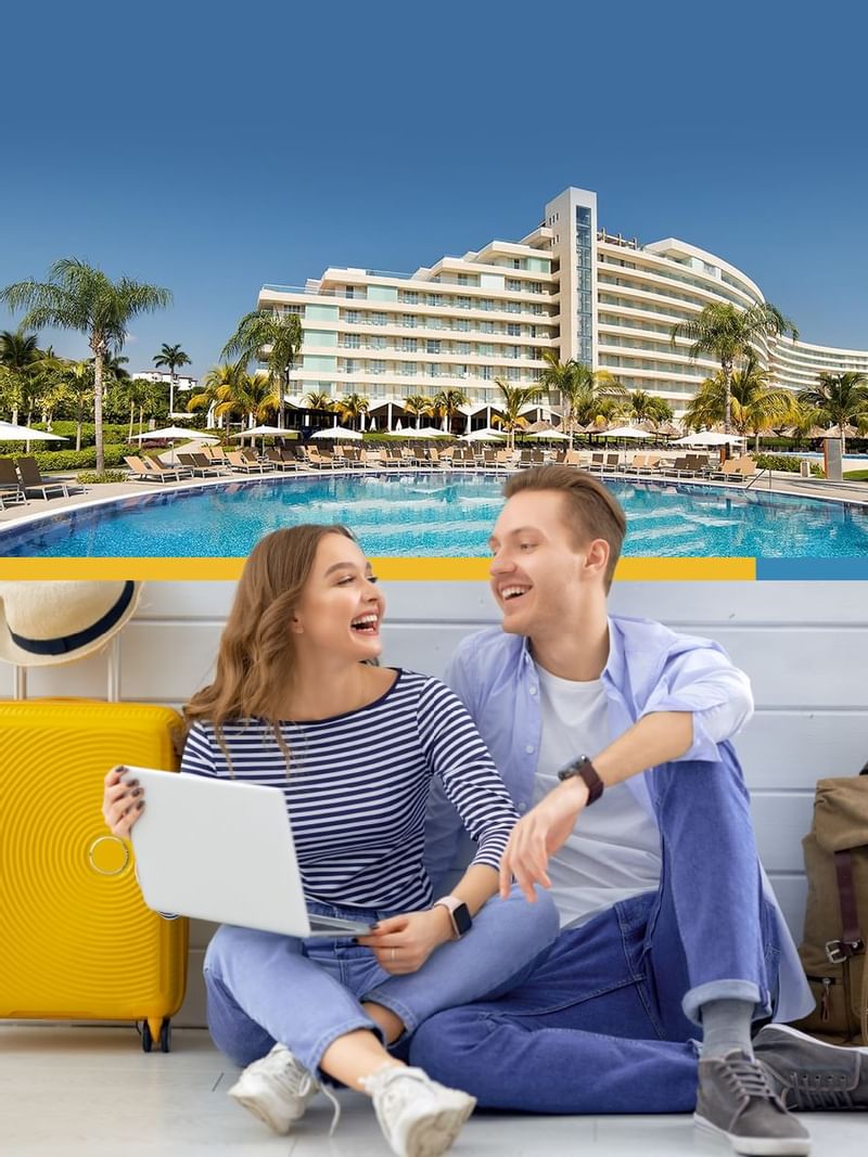 Travel couple with a laptop laughing at Mundo Imperial