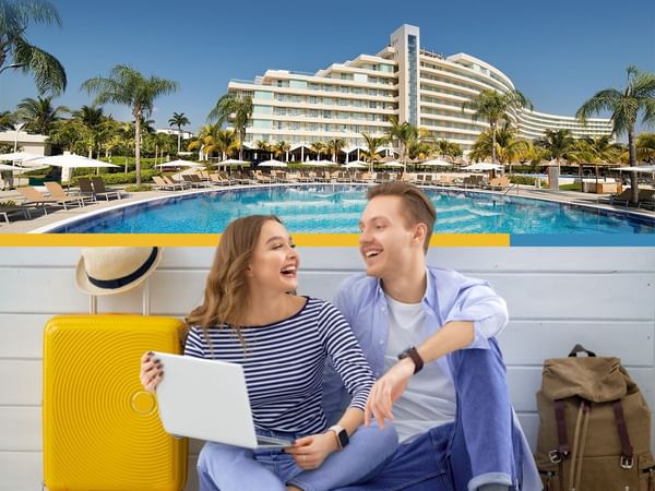 Travel couple with a laptop laughing at Mundo Imperial
