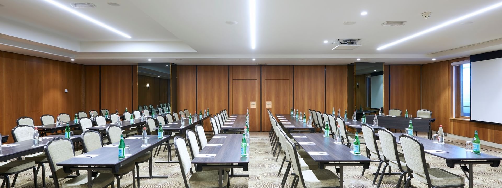 Aménagement moderne d'une salle de réception avec des rangées de tables et de chaises au Warwick Grand-Place Brussels.