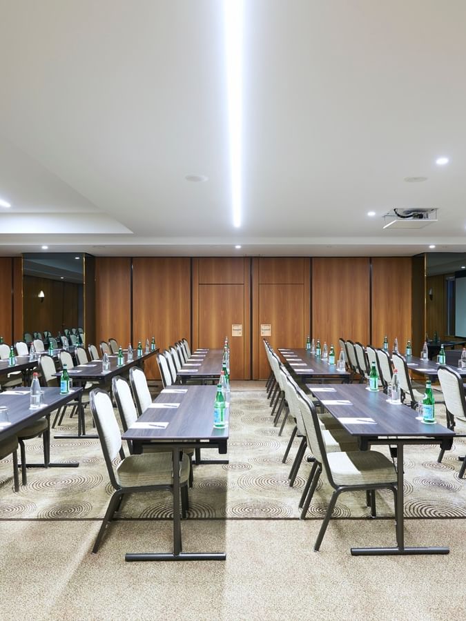 Aménagement moderne d'une salle de réception avec des rangées de tables et de chaises au Warwick Grand-Place Brussels.