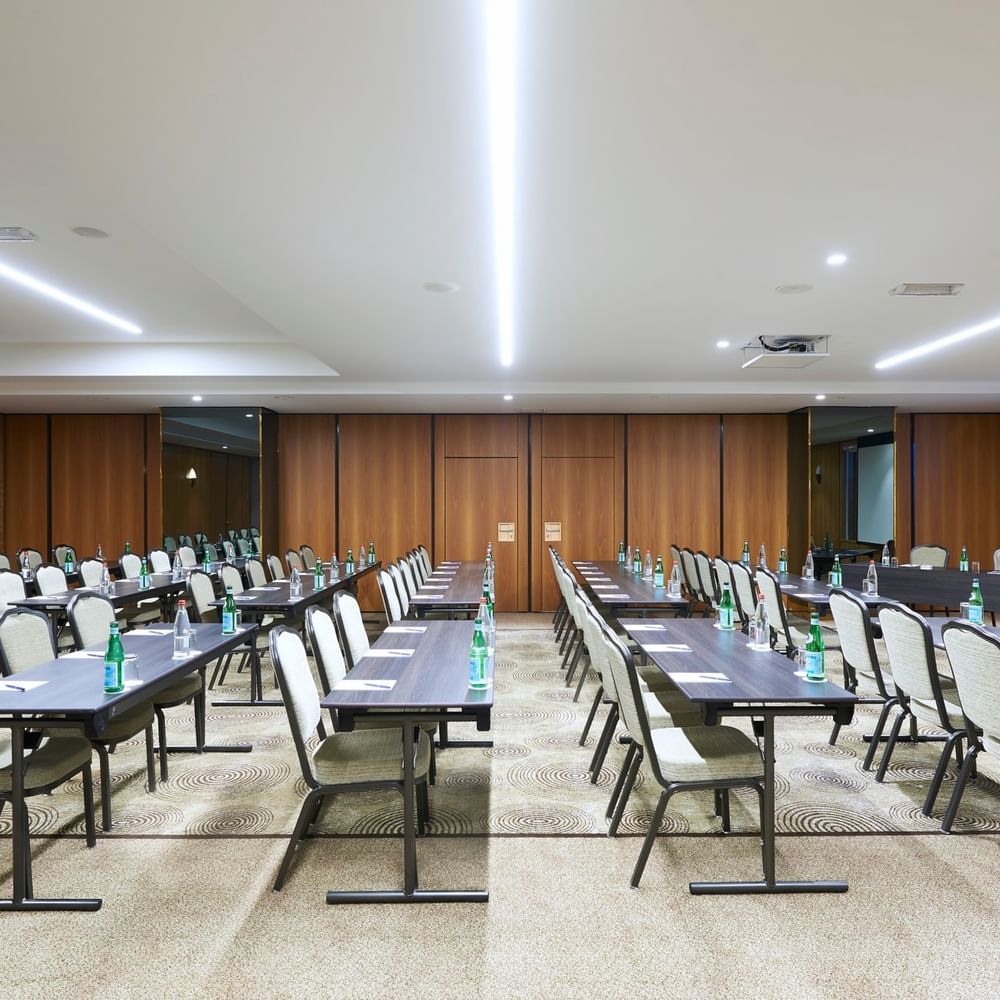 Aménagement moderne d'une salle de réception avec des rangées de tables et de chaises au Warwick Grand-Place Brussels.