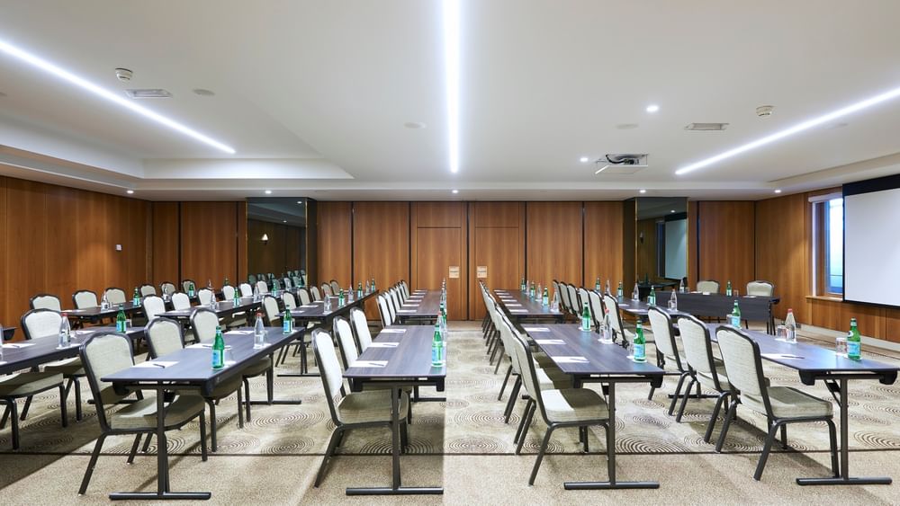 Aménagement moderne d'une salle de réception avec des rangées de tables et de chaises au Warwick Grand-Place Brussels.