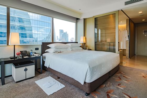 King bed in Deluxe Corner with city view at The Okura Prestige