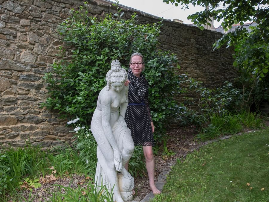 A lady posing to camera with a statue at Clos de Vallombreuse
