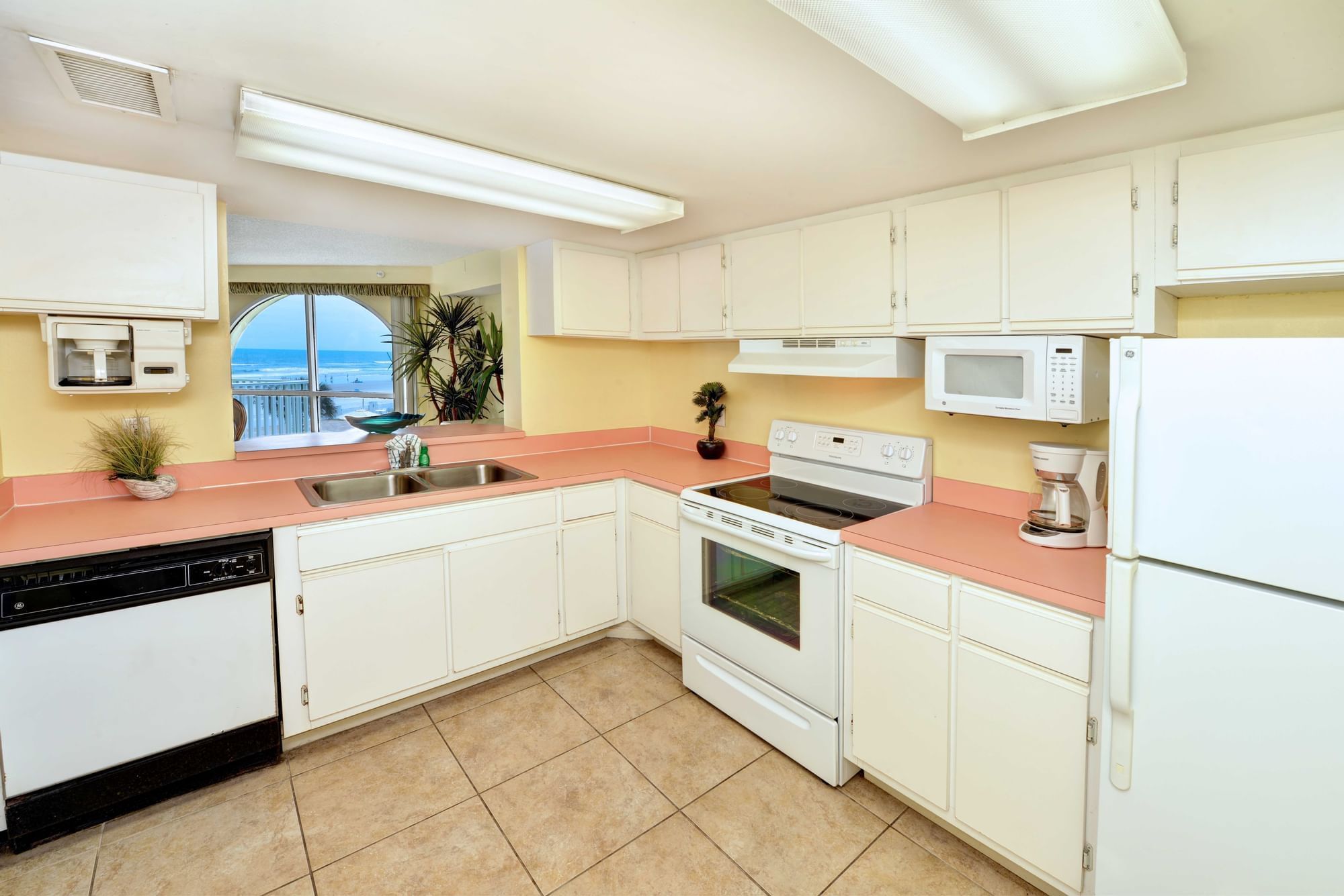 a kitchen with pink countertops and white cabinets