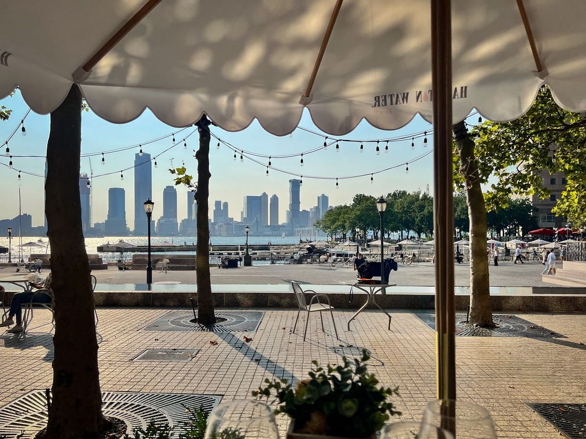 Scenic outdoor patio view of the city harbor and tall buildings near Warwick New York