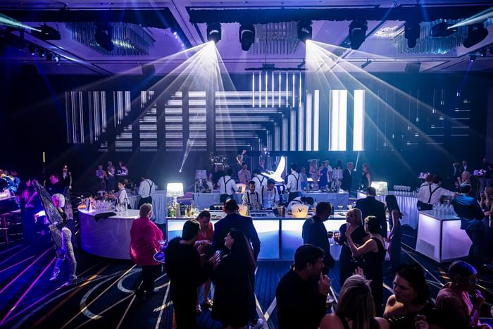 Modern event space with dramatic lighting effects and guests at Sofitel Brisbane Central