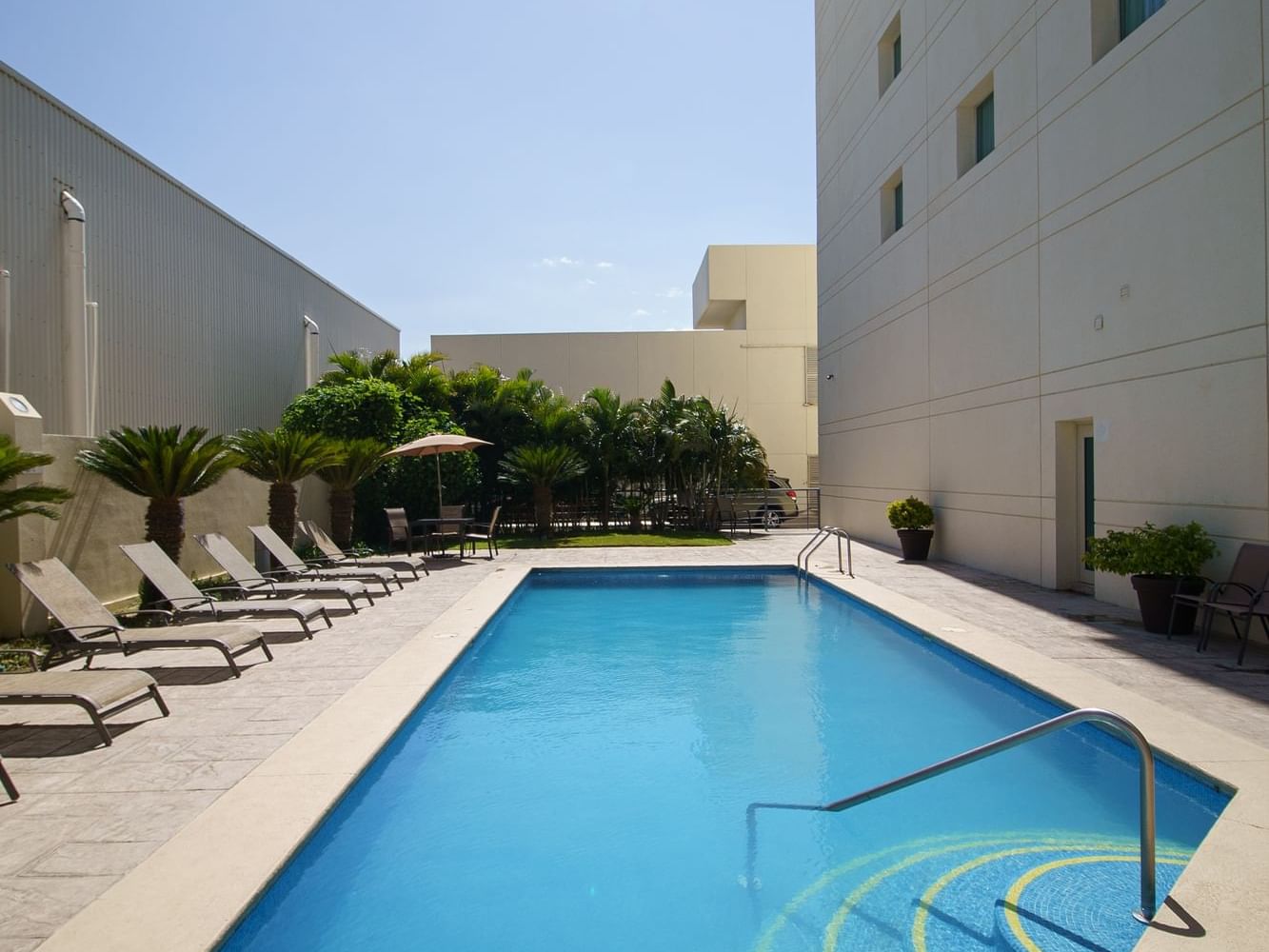 Outdoor pool with sunbeds at Hotel Aeropuerto los Cabos