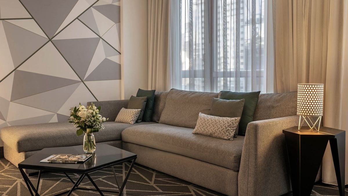Élégant salon de la suite junior, au décor moderne et à l'ameublement confortable, au Warwick Le Crystal – Montréal.