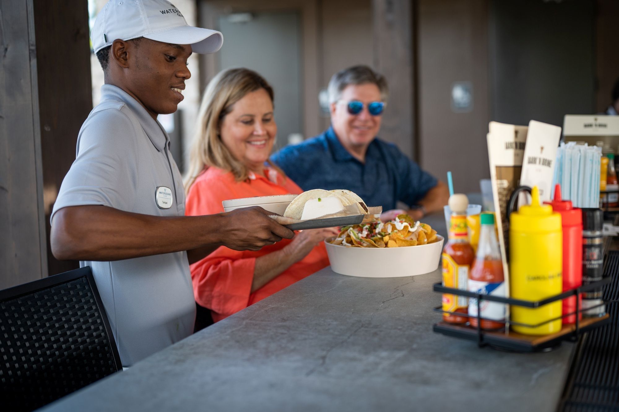 Server preparing food at Bark 'N Brine restaurant at Camp Creek Inn in Inlet Beach.