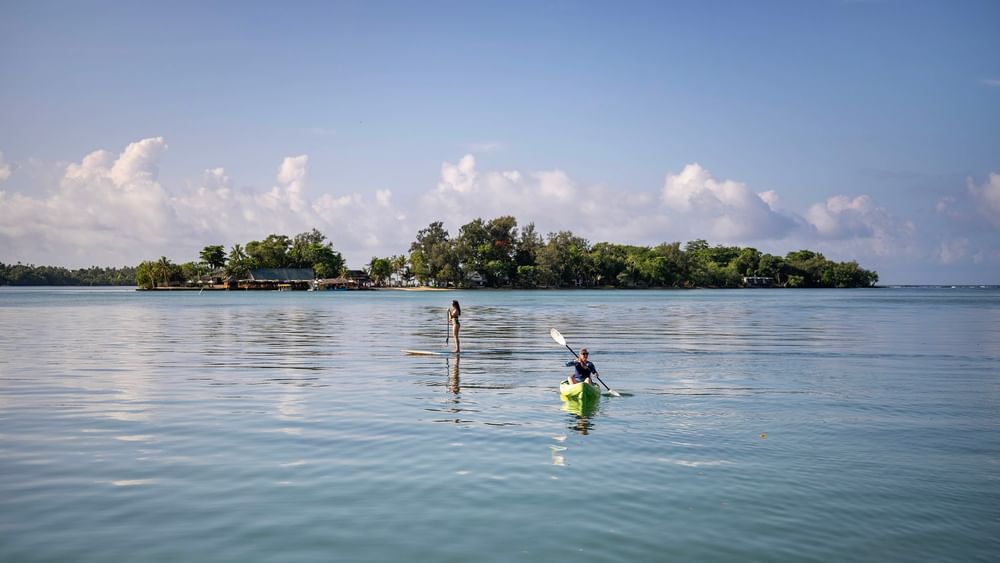Two people enjoying kayaking and paddleboarding on tranquil waters at Warwick Le Lagon in Efate.