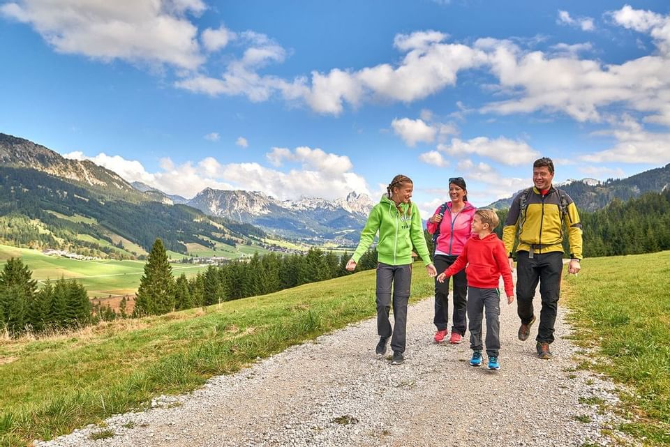 A family walking along a road by a valley near Liebes Rot Flueh