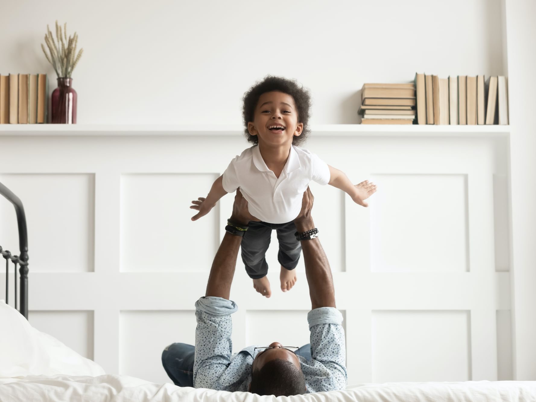 A father lifting up a child on bed