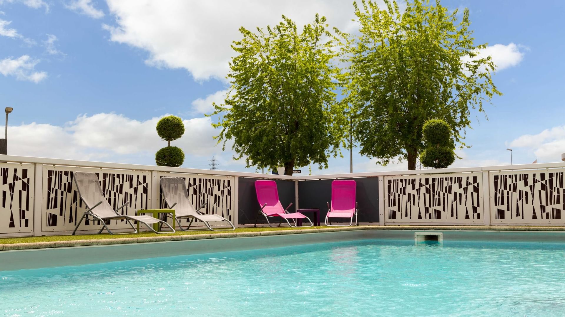 View of the pool chairs from the pool at Originals Hotels