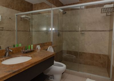 Baño de hotel privado con ducha, zona de tocador y retrete en la habitación del hotel The Beach House de Panamá