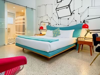 A wide angle view of the ADA Catalina king showing the bathroom and bedroom area an open plan view into the shower area