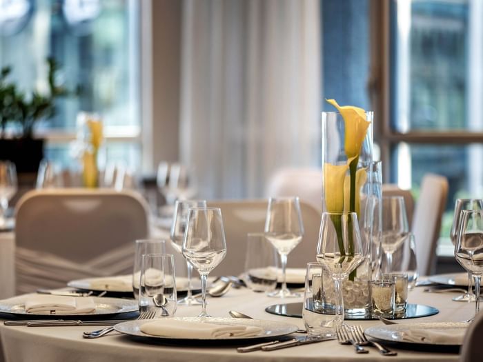 Elegantly set dining table with floral centerpiece in Ballroom at Warwick Le Crystal Montreal