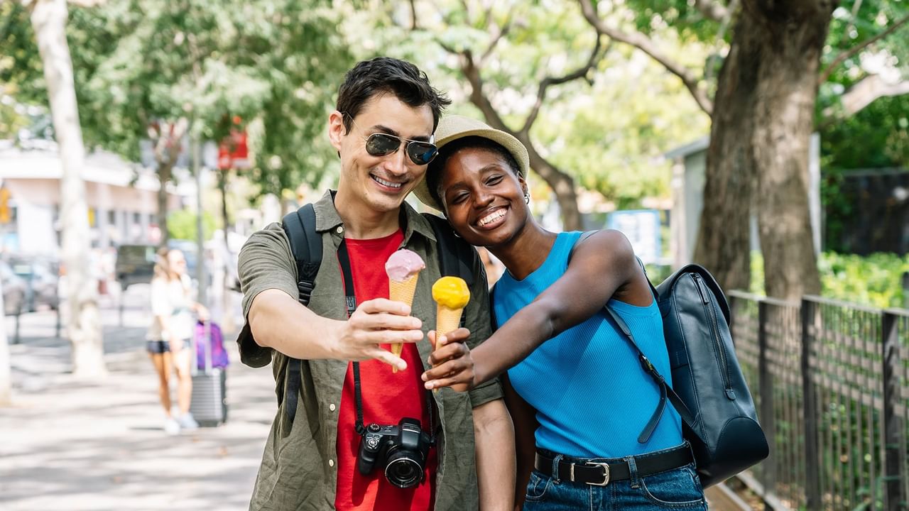 Couple smiling and posing with ice creams.