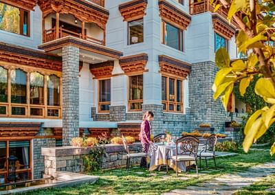 Lady setting up a dining table outdoors at The Indus Valley Leh, luxury hotel in Leh Ladakh