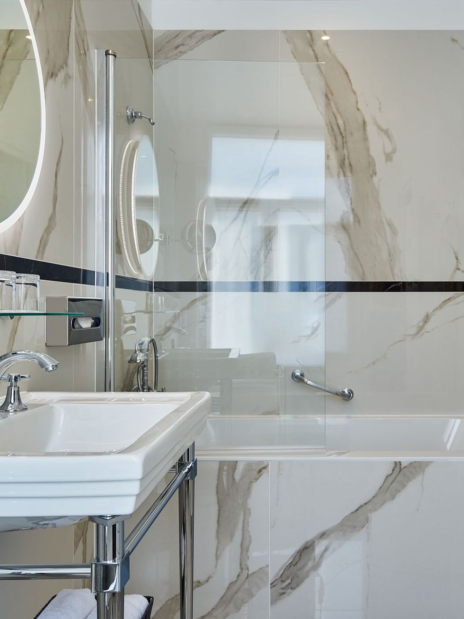 Executive Room – Rue de la Paix View bathroom featuring a marble vanity by the glass shower at Hotel Westminster Paris