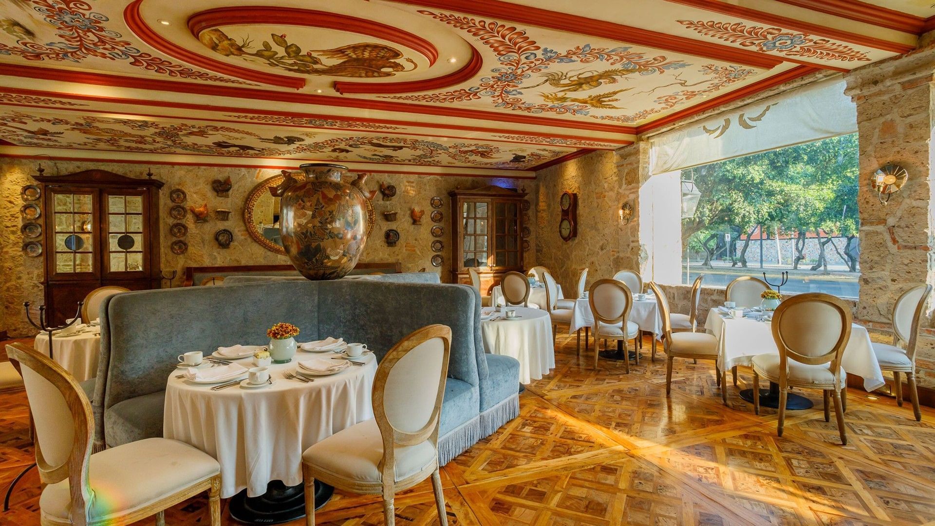 Tierra Mia restaurant featuring patterned wood floors, white chairs, and tables at Quinta Real Guadalajara