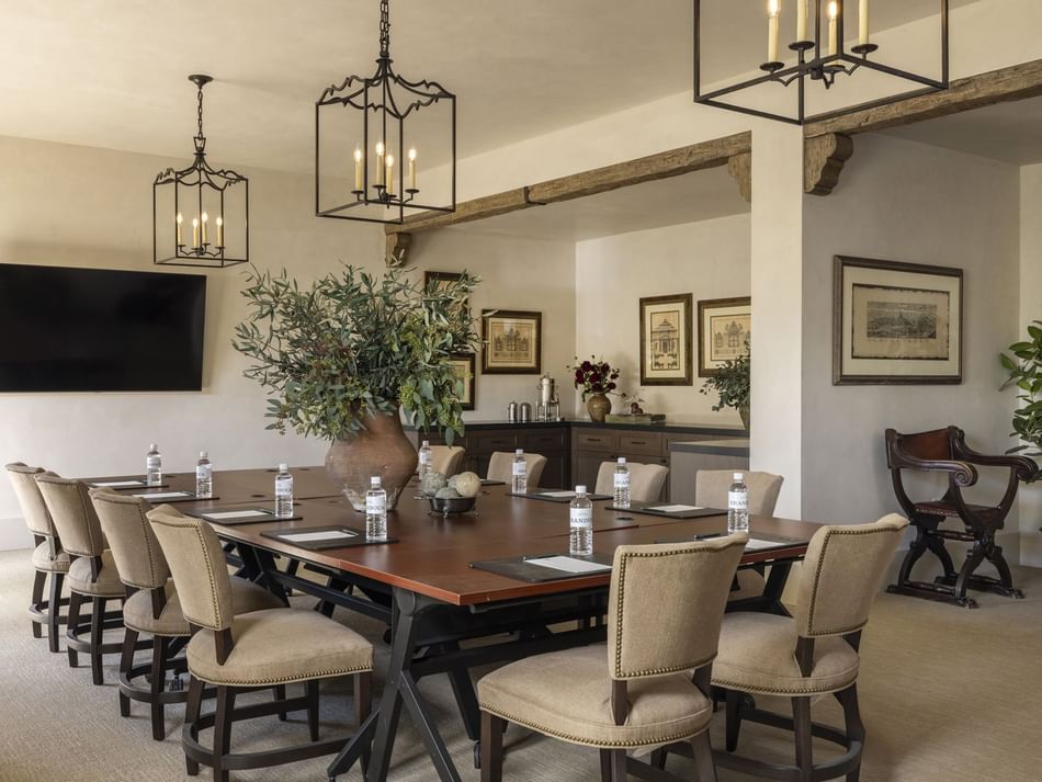 The Jessamine Room at Granduca Houston, one of the elegant event spaces in Houston, with a wooden table, chairs, and a TV