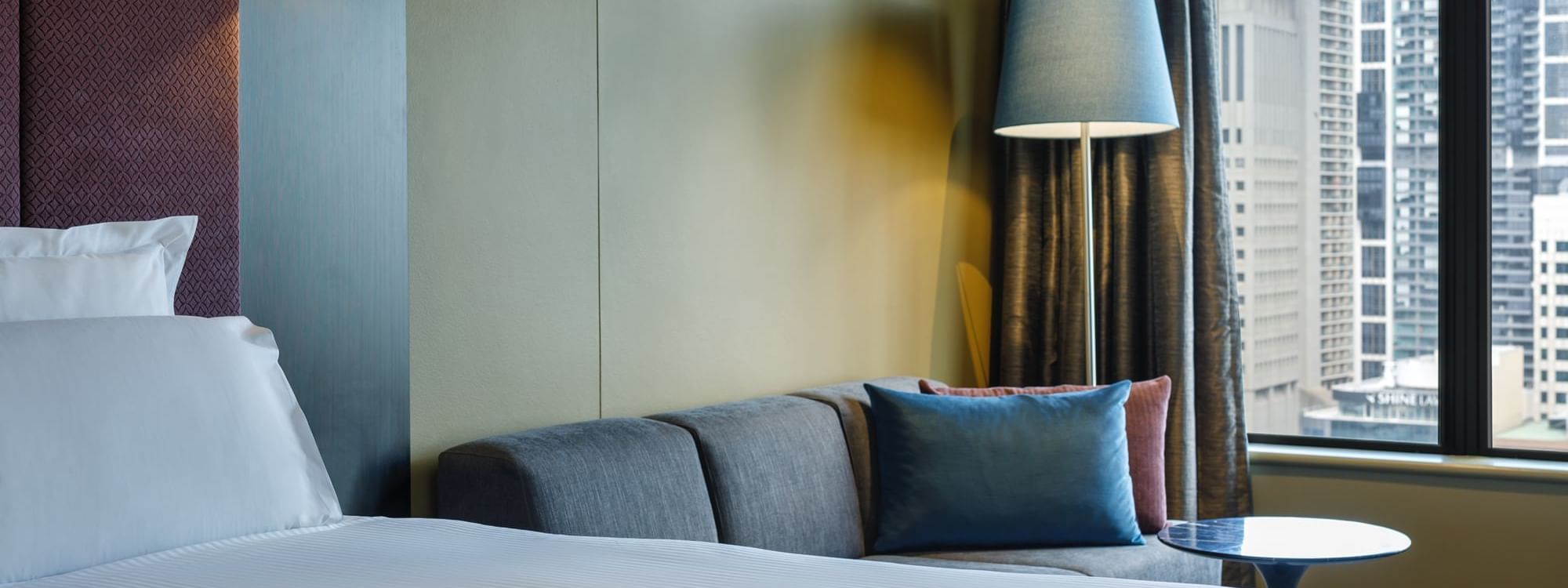 Lounge area by the comfy bed in Deluxe Room at Pullman Sydney Hyde Park